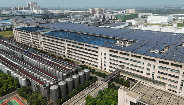 Letecký pohled na velký průmyslový areál se solárními panely na střeše, kde je detailní měření spotřeby energie nutností.